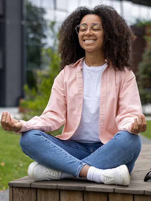 Student practices meditation in an outdoor setting.