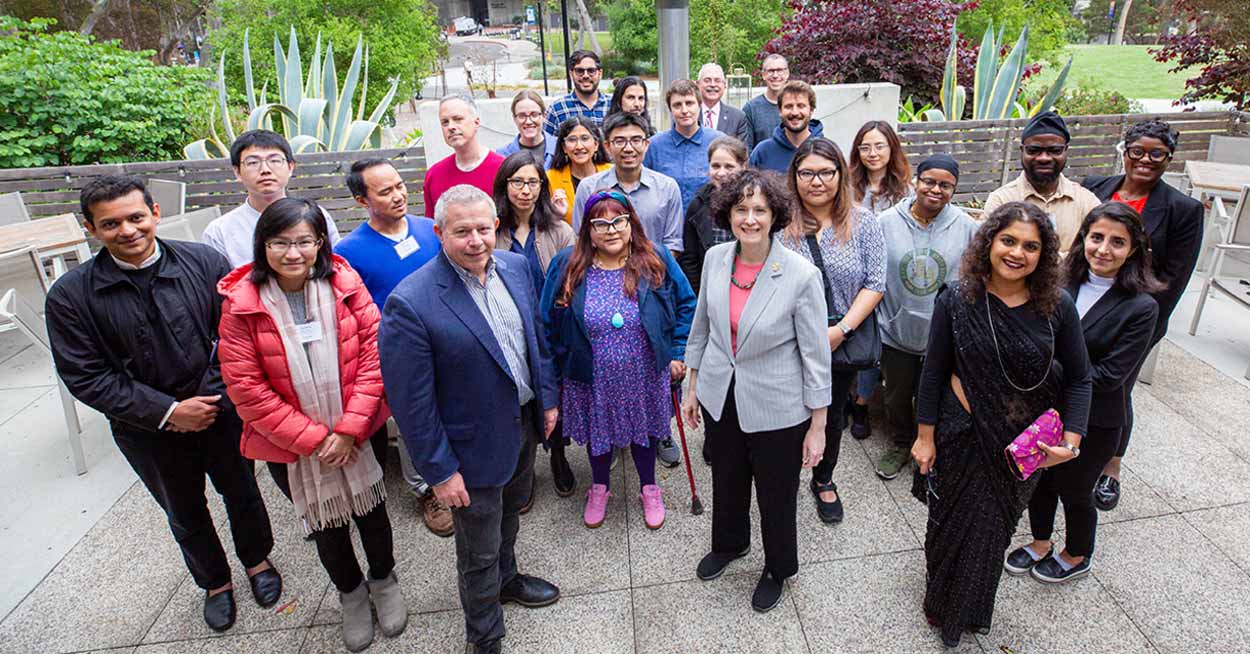 Student handles lab equipment while another lab member observes